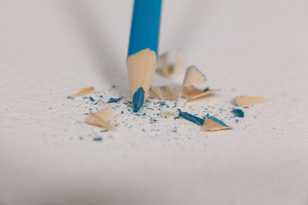 Blue colored pencil with broken tip on white backgroundの写真素材