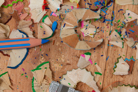 Close-up of sharpener and colored pencil with shavings on wooden backgroundの写真素材