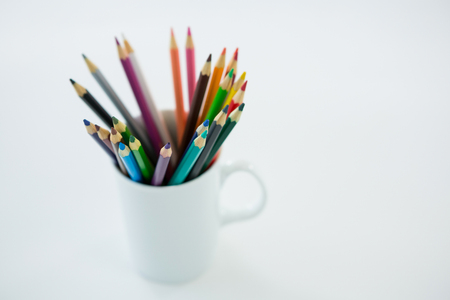 Colored pencils kept in mug on white backgroundの写真素材