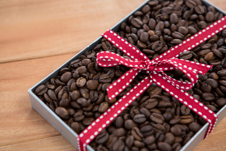 Roasted coffee beans in gift box on wooden backgroundの写真素材