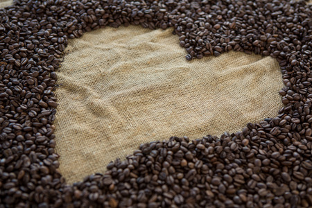 Coffee beans forming heart shape on sack textileの写真素材