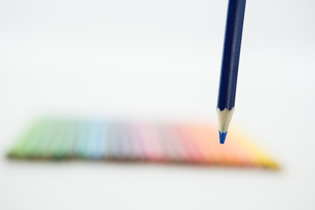 Colored pencils arranged in a row on white backgroundの写真素材