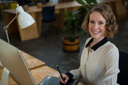 Portrait of female graphic designer using graphic tabletの写真素材