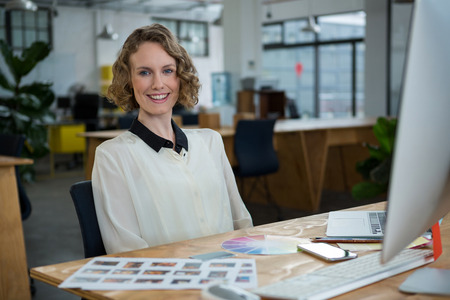 Female graphic designer working at desk in creative office