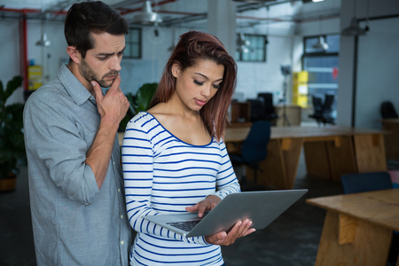 Man and woman using laptop  in creative officeの写真素材