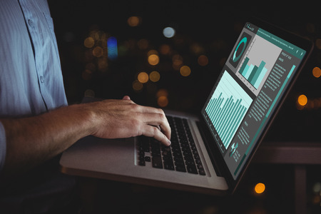 Business interface with graphs and data against man using laptop at home