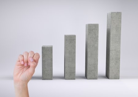 Digital Composite Image of a Hand next to graph against a grey backgroundの写真素材