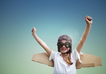 Boy with aviation glasses pretending to be a pilot against blue backgroundの写真素材