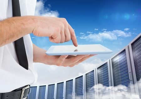Digital composition of man using digital tablet against office building in background