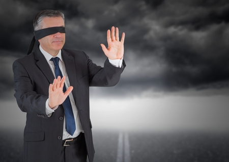 Digitally composite image of businessman in blindfold against storm cloudの写真素材