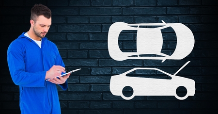 Automobile mechanic using digital tablet and car shapes on wall in backgroundの写真素材