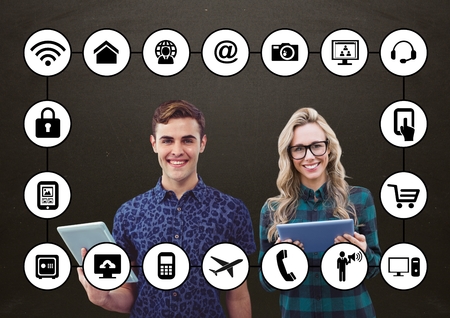 Digital composition of colleagues holding digital tablet with application icons on grey backgroundの写真素材