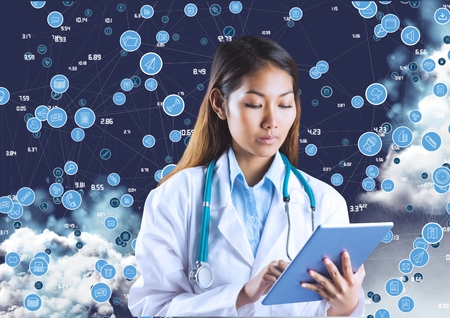 Female doctor with stethoscope using digital tablet against digitally generated iconsの写真素材