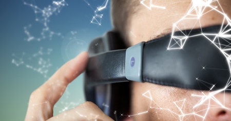 Man using virtual reality glasses against digitally generated backgroundの写真素材