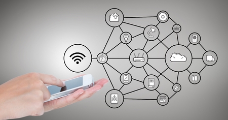 Digital composition of hands using mobile phone and network connecting icons against grey backgroundの写真素材
