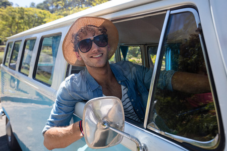 Man looking out from window while driving campervan on a sunny dayの写真素材