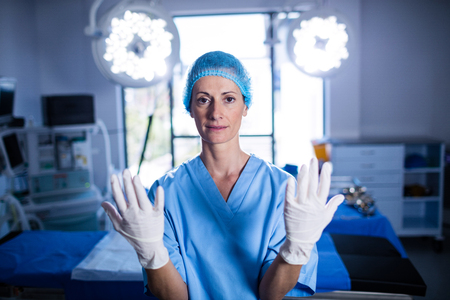 Portrait of female surgeon preparing for operation in operation room at the hospitalの写真素材