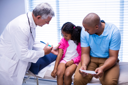Doctor giving an injection to the patient at hospitalの写真素材