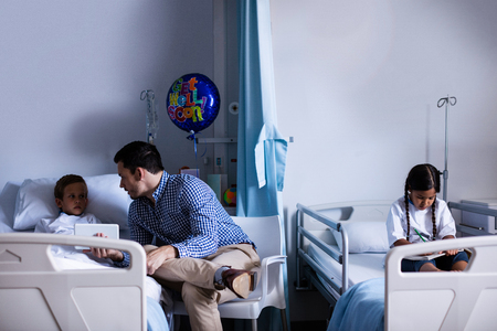 Father and son using digital tablet at hospitalの写真素材
