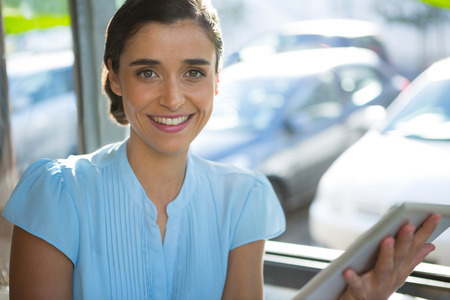 Portrait of female executive using digital tablet at caféの写真素材