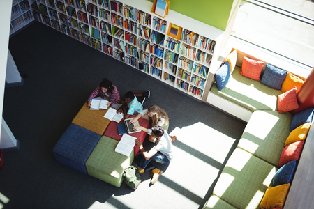 Overhead view of attentive students studying in library at schoolの写真素材