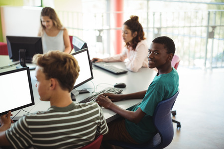 Students using computer in classroom at school