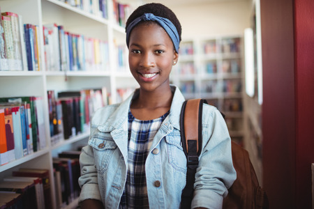 Portrait of smiling schoolgirl in library at school