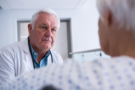Doctor interacting with senior patient at hospitalの写真素材