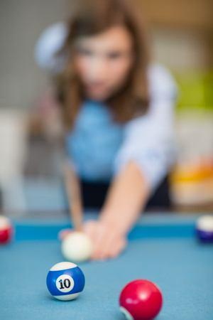 Business executive playing pool in office space