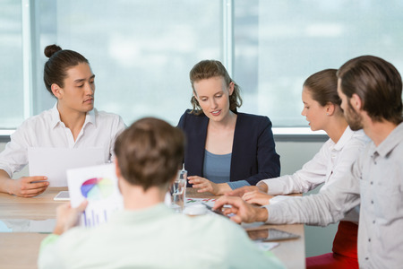 Business executives discussing with each other in conference room at office