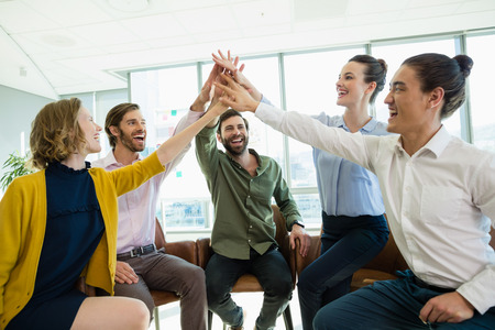 Business executives giving high five to each other at office