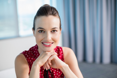 Portrait of smiling female business executive sitting in officeの写真素材