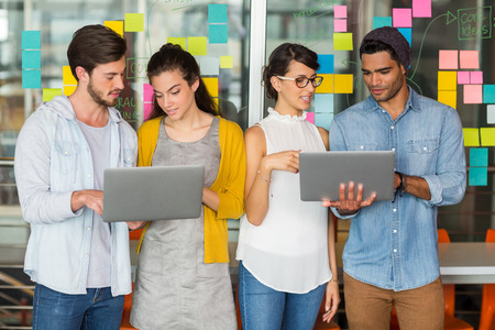 Attentive executives discussing over laptop in office