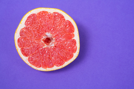 Slice of grapefruit on purple backgroundの写真素材