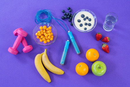 Various fitness accessories on purple background