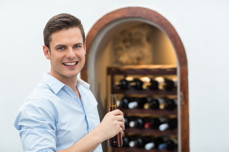 Portrait of handsome man holding beer bottleの写真素材