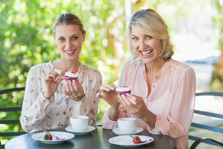 Portrait of smiling friends enjoying coffee together at restaurantの写真素材