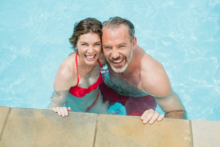 Portrait of happy couple in swimming pool on a sunny dayの写真素材
