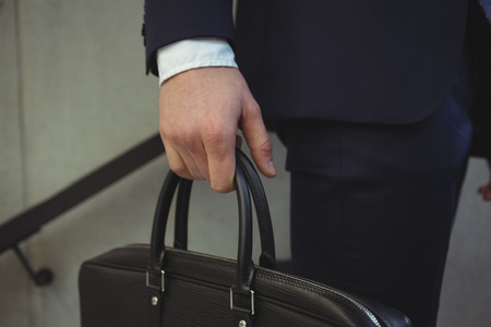 Low section of businessman holding briefcaseの写真素材