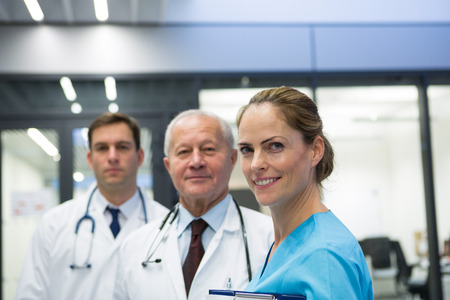 Portrait of smiling doctors and surgeon together standing in hospital