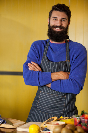 Portrait of male staff standing with hands crossed at organic section in supermarketの写真素材
