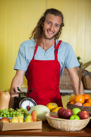 Portrait of smiling staff standing at counter in marketの写真素材