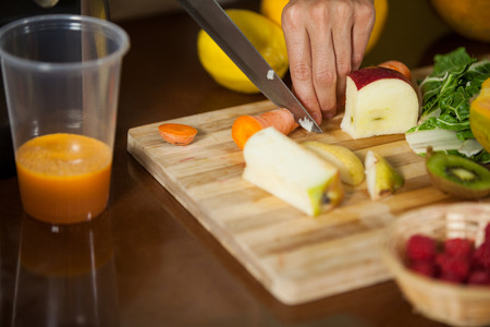 Staff chopping carrot at counter in health grocery shop