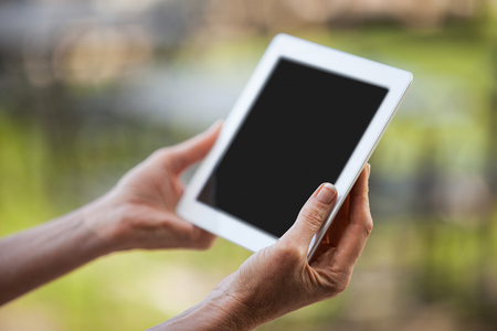 Hands of female staff using digital tablet in supermarket