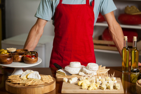 Mid-section of staff standing at counter in marketの写真素材