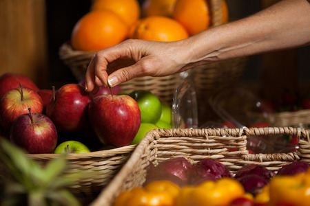 Hand of female staff holding apples in organic section of supermarketの写真素材
