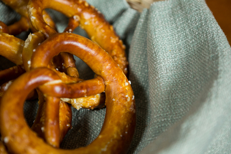 Close-up of pretzel breads in wicker basket at counter in bakery shop