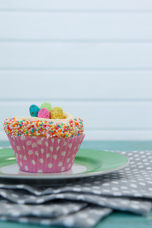 Close-up of cupcake with Easter eggs served in plate on a napkinの写真素材
