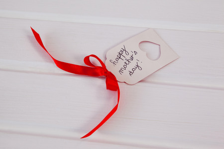Close-up of happy mothers day card on wooden surfaceの写真素材