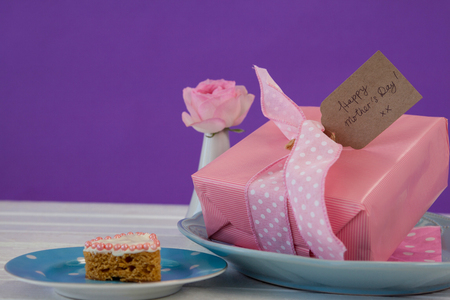 Close-up of gift box, flower vase and cookie on wooden surfaceの写真素材